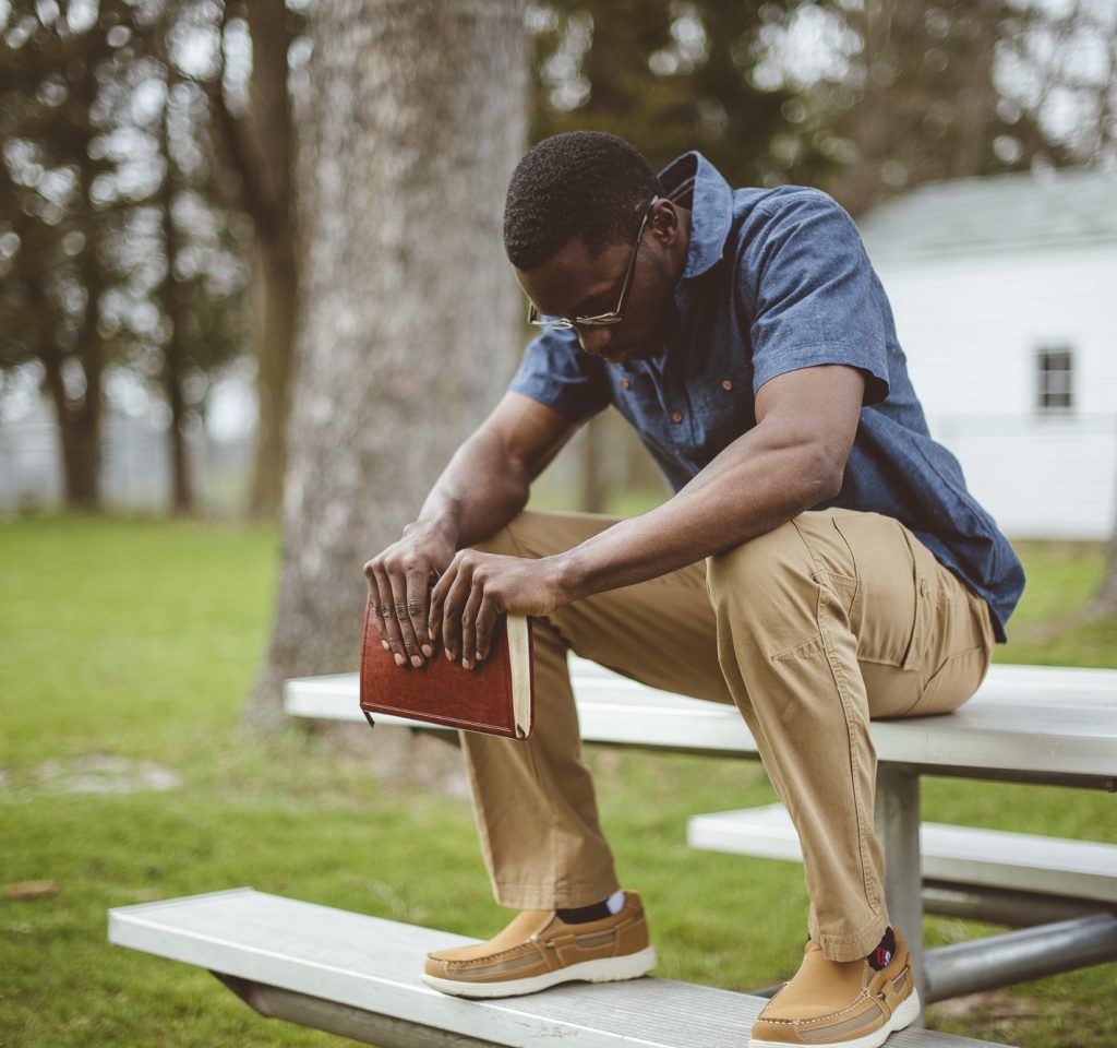young-african-american-male-sitting-with-closed-eyes-with-the-bible-in-his-hands.jpg